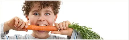 Young child biting into a carrot